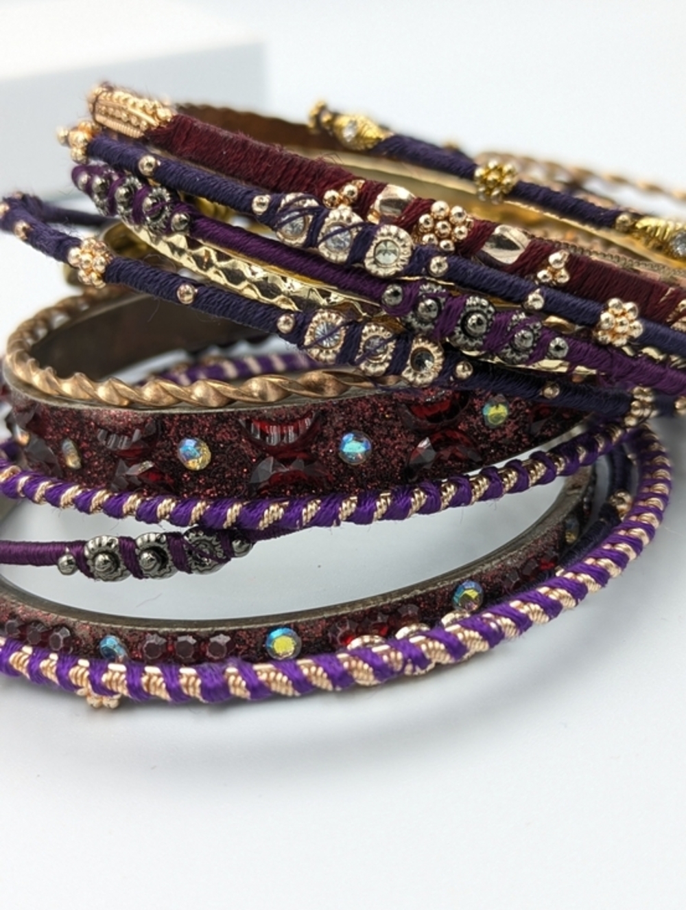 5/25$  Colourful selection of gold tone and thread bangle bracelets